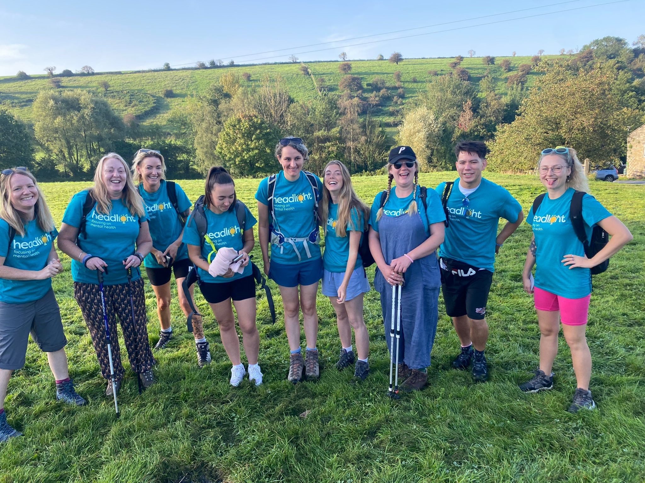 Image displays 9 women stood together in a field wearing charity walk t-shirts